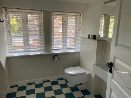 a bathroom with a toilet and a checkered floor at Frigga in Nieblum