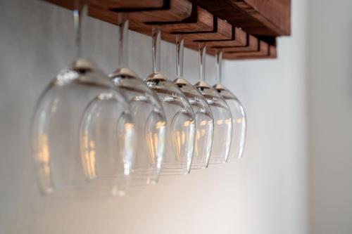 a row of wine glasses hanging from a rack at 4 Sterne Ferienwohnung , 65 qm in Quedlinburg