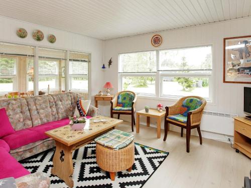 a living room with a couch and chairs and windows at 4 person holiday home in Hals in Hals