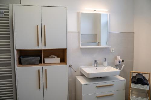 a white bathroom with a sink and a mirror at 4 Sterne Ferienwohnung , 65 qm in Quedlinburg