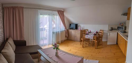 a small living room with a table and a kitchen at Apartmány 105 in Habovka