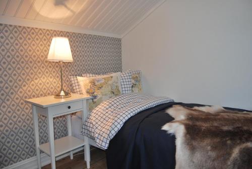 1 dormitorio con 1 cama y 1 mesa con lámpara en Våffelcafé Bed & Breakfast, en Dannäs