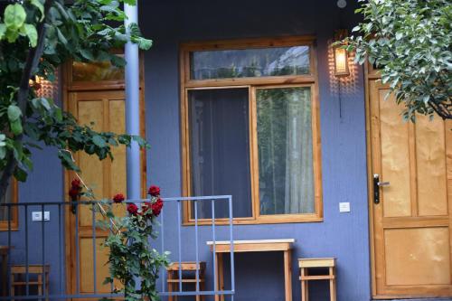 a blue house with a door and two stools at Andranik B&B in Goris