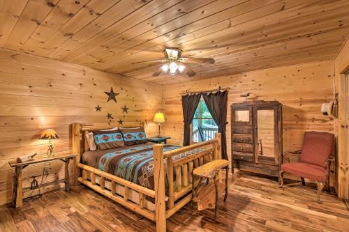 Dormitorio en cabaña de madera con cama y ventilador de techo en Dreamy Ellijay Resort Cabin with Game Room and Decks!, en Ellijay