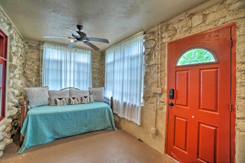 a bedroom with a red door and a stone wall at Enchanting Hilltop Cottage in Medicine Park! in Medicine Park