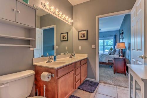 a bathroom with a sink and a toilet and a mirror at Lake View, Pool Access Idyllic Camdenton Condo! in Camdenton