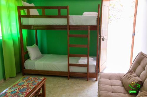 a room with two bunk beds and a couch at Pousada Green Place in Ribeira Grande