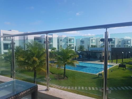 a view of a swimming pool from the balcony of a building at Praia do Forte- Iberostar- Ap Luxuoso 3 qts in Mata de Sao Joao