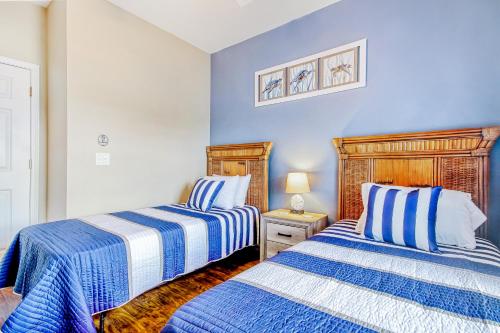 two beds in a room with blue walls at Coastal Escape in Myrtle Beach