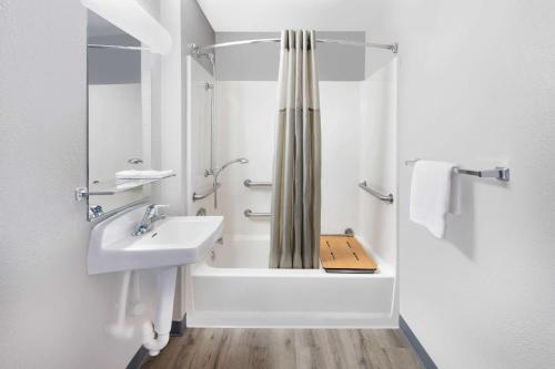 uma casa de banho branca com um lavatório e um chuveiro em Motel 6-Woodland, CA Sacramento Airport em Woodland