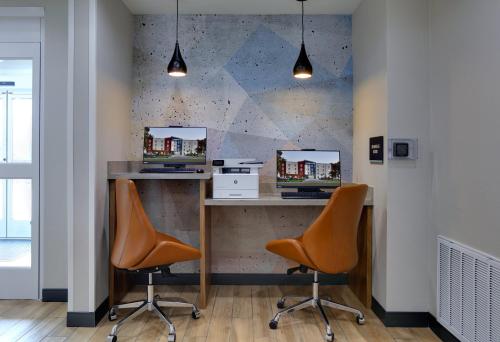 two orange chairs sitting at a desk in a office at Candlewood Suites DFW West - Hurst by IHG in Hurst
