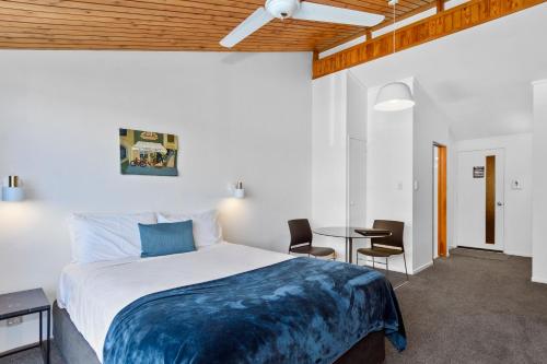 a bedroom with a bed and a table and chairs at The Tauranga on the Waterfront in Tauranga