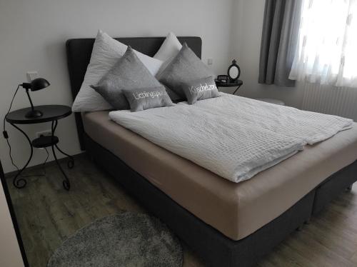 a bedroom with a bed with white sheets and pillows at Zum Scheunenhof - Scheune in Ichenhausen