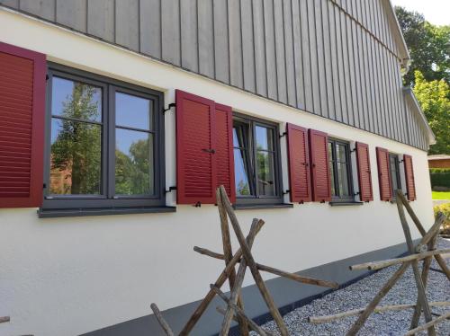 a row of red shuttered windows on a building at Zum Scheunenhof - Scheune in Ichenhausen
