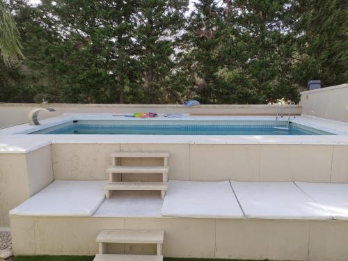 una piscina con panchina e scala di fronte di B&B Relax a Porto Cesareo