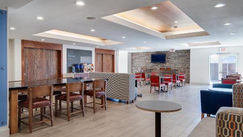 a restaurant with a bar with chairs and tables at Holiday Inn Express & Suites Dinuba West by IHG in Dinuba