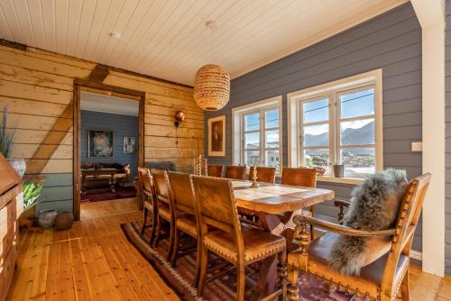 a dining room with a wooden table and chairs at Villa Borgvåg - A unique Seafront Villa in the heart of Lofoten in Bøstad