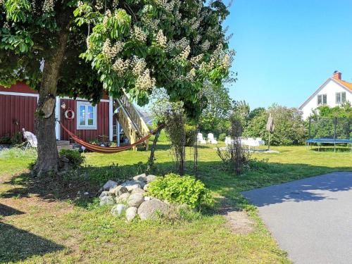 un parc avec une aire de jeux avec un arbre et un toboggan dans l'établissement 6 person holiday home in S LVESBORG, à Sölvesborg