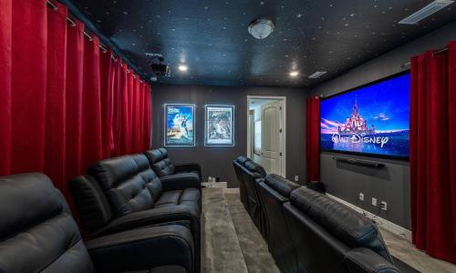 a cinema room with red curtains and a flat screen tv at Captivating 5 Bdrm Villa with Theater at Encore in Orlando