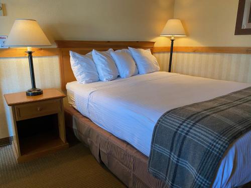 a hotel room with a large bed with two lamps at Cousin's Country Inn in The Dalles