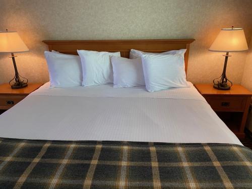 a large bed with white pillows and two lamps at Cousin's Country Inn in The Dalles