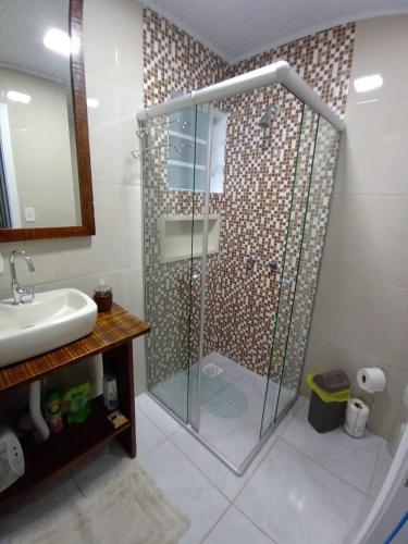 a bathroom with a shower and a sink at CASA OTTON - Casa aconchegante, 3 quartos com cama de casal todos com ar condicionado in Gramado
