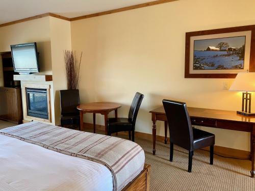 a hotel room with a bed and a desk and chairs at Cousin's Country Inn in The Dalles
