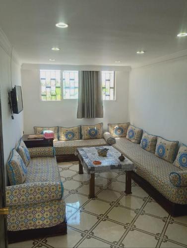 a living room with a couch and a table at bungalow de charme in El Harhoura