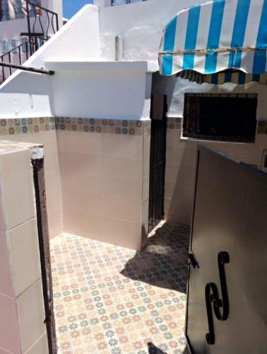 a kitchen with a counter top and a tile floor at bungalow de charme in El Harhoura