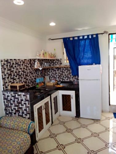 cocina con nevera y encimera en bungalow de charme en El Harhoura
