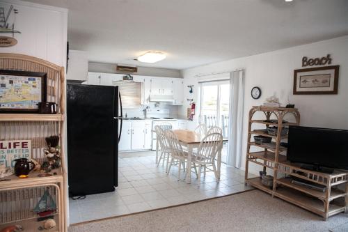 a kitchen with a table and a black refrigerator at 57218 Island Club Lane Home in Hatteras