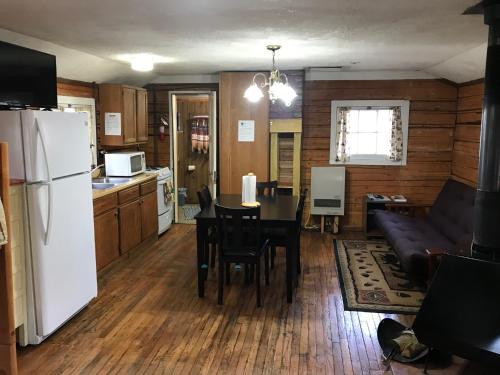 a kitchen and living room with a table and a refrigerator at Grandview Cabins & RV Resort in South Fork