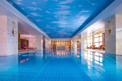 a swimming pool with a ceiling filled with clouds at Wyndham Grand Plaza Royale Colorful Yunnan in Kunming