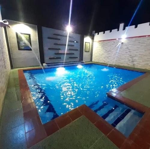 a large swimming pool in a building at night at Hotel Colonial Villavieja in Villavieja