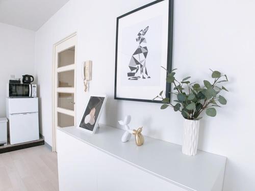 a white shelf with a vase of flowers and a mirror at OUCHI HOTEL Kanayama-cho with Dogs in Hiroshima