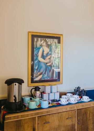 a painting of a woman in a blue dress on a wooden cabinet at Casa Nova House in Oamaru