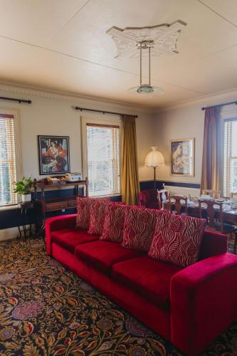 a living room with a red couch and a table at Casa Nova House in Oamaru