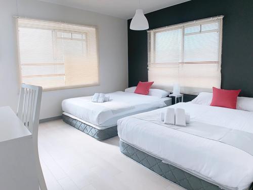 a bedroom with two beds with red pillows at OUCHI HOTEL Kanayama-cho with Dogs in Hiroshima