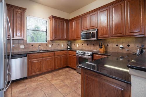 a kitchen with wooden cabinets and a stove top oven at Villa at Canyon Lake CL 1233 in Canyon Lake