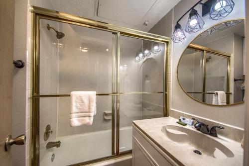 y baño con ducha, lavabo y espejo. en Ripley River Haus IC 302, en New Braunfels