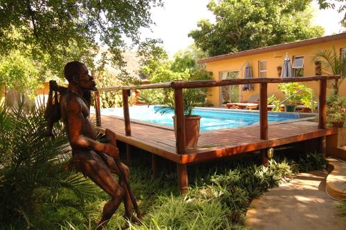 a statue of a woman sitting next to a pool at Normann Safari Bush Lodge in Phalaborwa