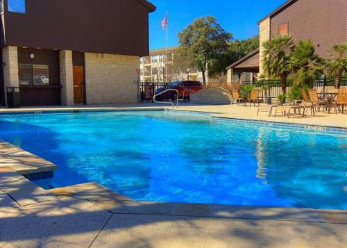 a large blue swimming pool in front of a building at The Iron Cactus Condo on the Comal CW C102 in New Braunfels