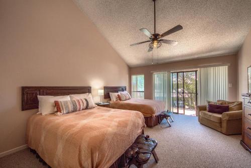 sypialnia z 2 łóżkami i wentylatorem sufitowym w obiekcie The Iron Cactus Condo on the Comal CW C102 w mieście New Braunfels