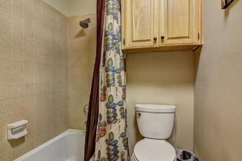 a bathroom with a toilet and a shower curtain at Go With The Flow CW B103 in New Braunfels