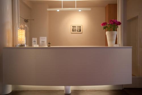 a counter with a vase of flowers on it at Hotel Van Bunnen in Knokke-Heist