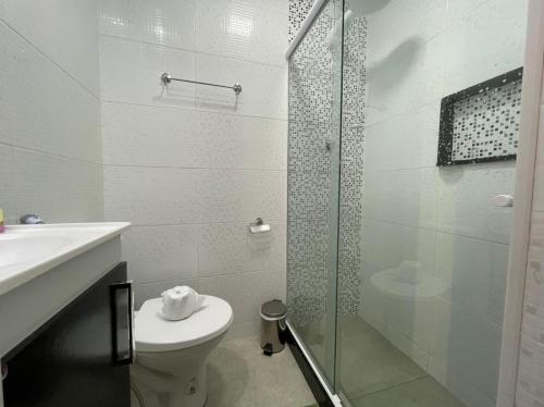 uma casa de banho com um WC e uma cabina de duche em vidro. em Studio Buckingham Palace em Teresópolis