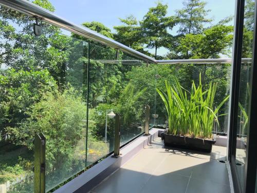 a glass house with plants on a balcony at Bạch Yến T111-Happy Villa Đại Lải Resort in Vĩnh Phúc