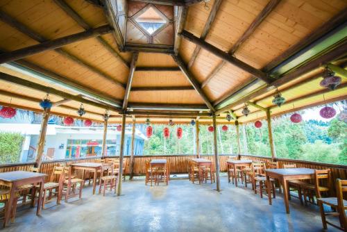 ein Esszimmer mit Tischen und Stühlen in einem Gebäude in der Unterkunft Long Yun Leisure Farm in Fenchihu