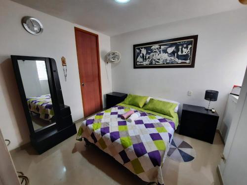 カルタヘナ・デ・インディアスにあるApto cómodo, confortable para descansar y Disfrutarのベッドルーム(ベッド1台、鏡付)
