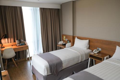 A bed or beds in a room at Allstay Hotel Semarang Simpang Lima